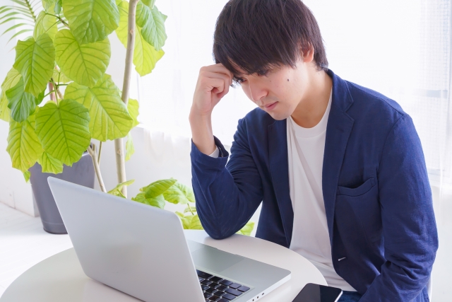 画面の前で悩む男性